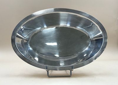 une assiette en argent posée sur un support métallique, sur une table