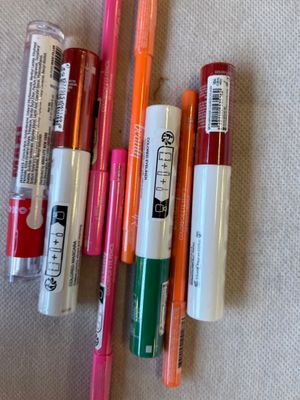 Plusieurs stylos sont alignés sur une table