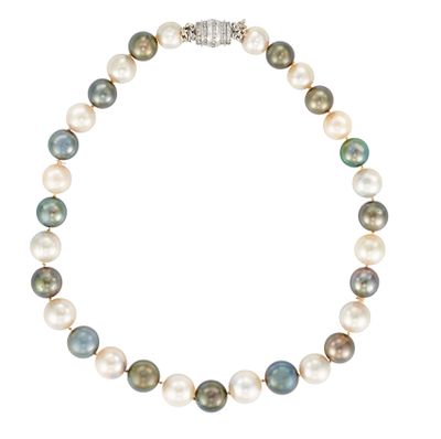 un collier de perles blanches et vertes avec un fermoir en argent