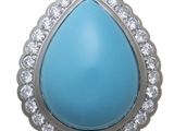 a close up of a turquoise stone and diamond pendant