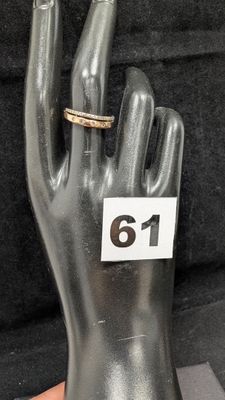une main à laquelle est passée une bague sur laquelle figure un chiffre