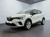 Une voiture blanche est garée dans une pièce blanche au sol noir.