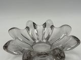 an image of a clear glass flower shaped dish on a white surface