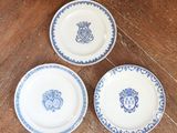 trois assiettes ornées de motifs bleus et blancs, posées sur une table en bois