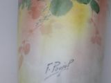 a hand holding a vase with flowers painted on it