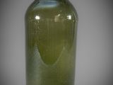a green glass vase that is sitting on a table