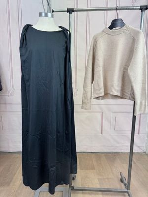 two sweaters hanging on a clothes rack in a room
