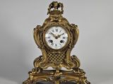 une horloge ancienne avec un cadre doré et un cadran blanc