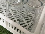 many empty glasses in the dishwasher on the grass