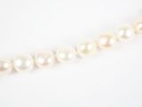 gros plan d'un collier de perles blanches sur une surface blanche