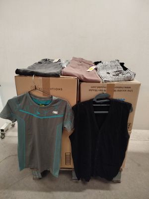 Des cartons de vêtements sont empilés les uns sur les autres dans une pièce