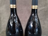 deux bouteilles de vin posées sur une table l'une à côté de l'autre