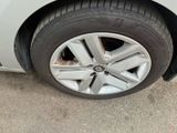 a cat that is sitting on the rim of a car