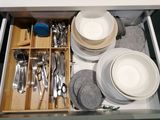 a drawer full of dishes and utensils in a kitchen