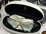 many pairs of sunglasses and a pair of glasses on a table