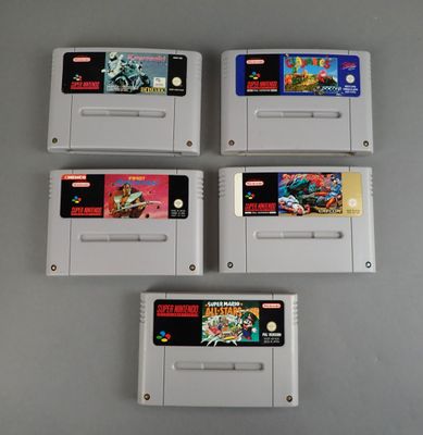 quatre cartouches de jeux Nintendo posées sur une table