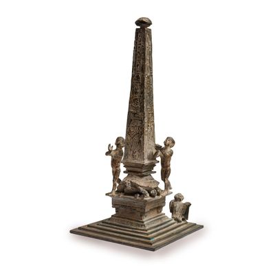 statue représentant un obélisque sur un socle, entourée de personnages
