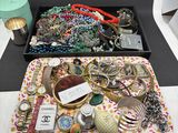 un plateau sur lequel sont disposés de nombreux bijoux de toutes sortes