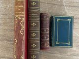trois vieux livres posés les uns à côté des autres sur une table en bois