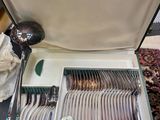 une valise posée sur une table, contenant de l'argenterie