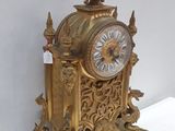 a gold clock sitting on top of a white table