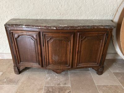 une armoire en bois avec un plateau en marbre, posée sur un sol carrelé