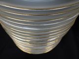 a white vase with gold stripes on it on a black background
