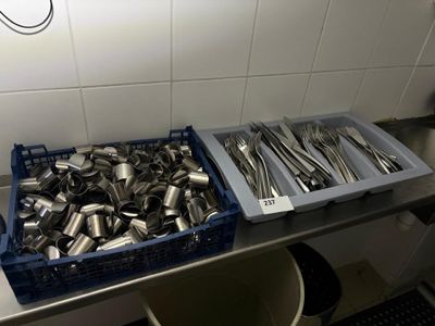 two bins of silverware sitting on a kitchen counter