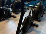 many exercise bikes in a gym room with a large window