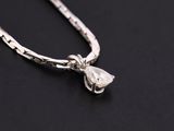 a close up of a silver necklace on a black surface