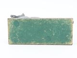 a small green box with a piece of paper on top of it