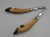 pair of dog paw claws with metal handles on a white surface