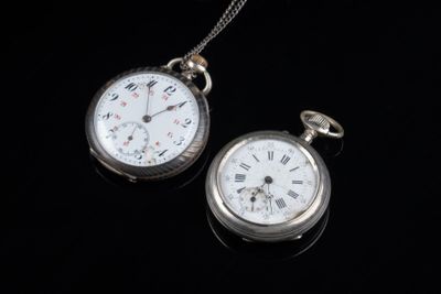 une montre de poche en argent et une autre montre de poche en argent posées sur une surface noire
