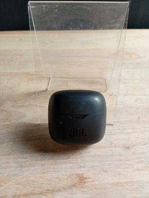 un petit objet noir posé sur une table en bois