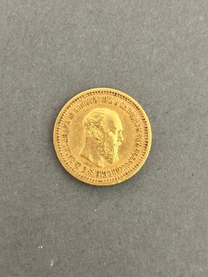 a close up of a gold coin on a gray surface
