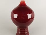 une image représentant un vase rouge sur fond blanc