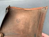 a hand holding a wallet that has a hole in it