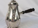 une cafetière ancienne en argent avec une poignée en bois sur fond blanc