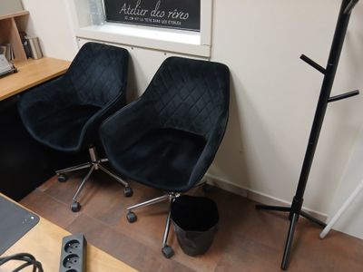 deux chaises dans un coin d'une pièce avec un tableau noir au mur