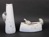 two white vases with birds on them sitting next to each other