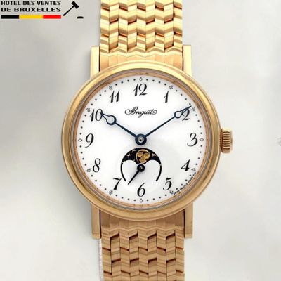une montre-bracelet en or avec un cadran blanc et un bracelet en or