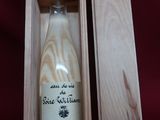 an empty bottle of wine in a wooden box on a red cloth
