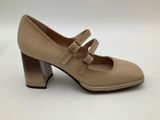 a pair of beige shoes with a wooden heel and two straps