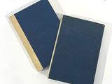 two books sitting next to each other on a white surface