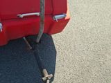 a red truck with a chain attached to the back of it