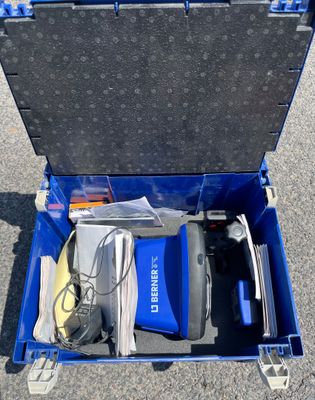 a blue tool box with tools in it sitting on the ground
