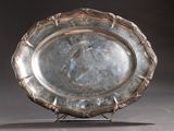 a silver plate that is on a stand on a table