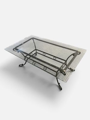 an image of a glass coffee table with metal legs and a glass top