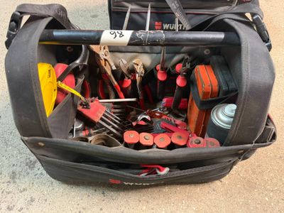 un sac rempli d'outils posé par terre