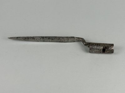 un petit objet métallique sur une surface blanche